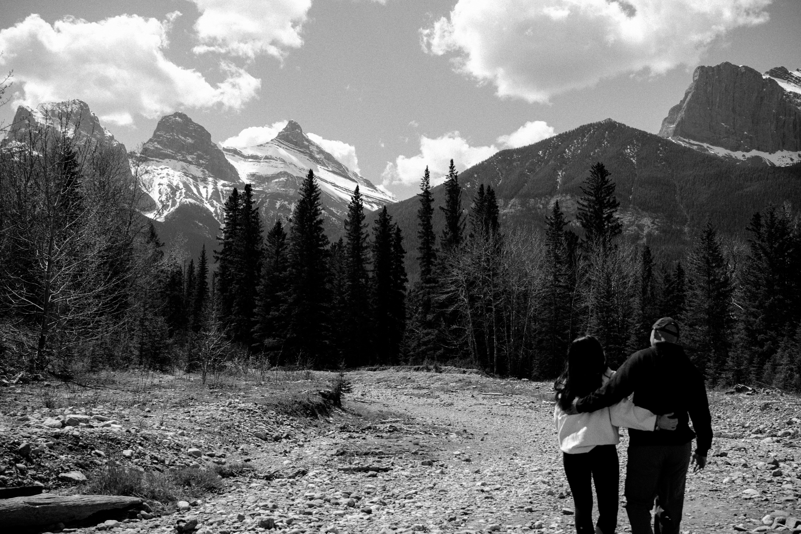Couple embracing as they walk near Three Sisters Viewpoint in Canmore, Alberta
